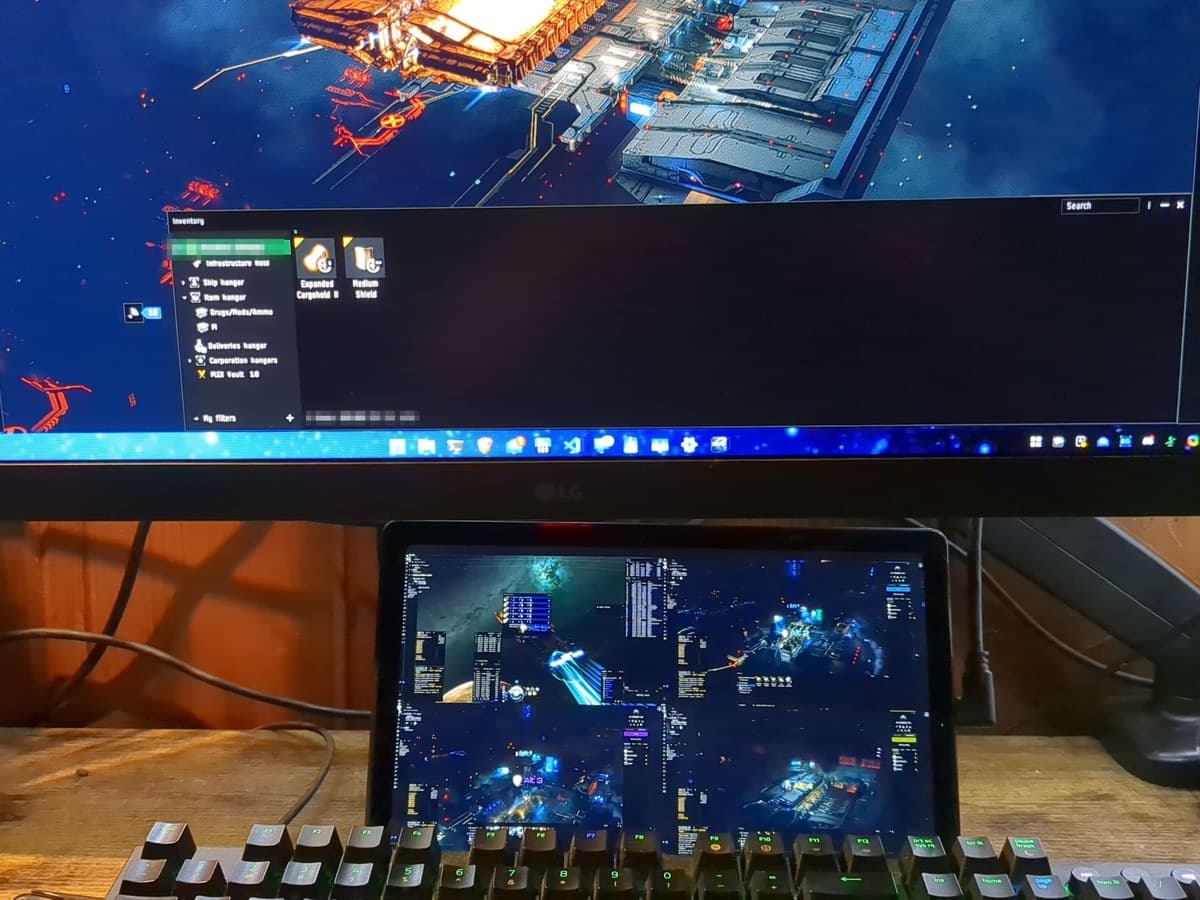 A real desk setup: an LG monitor running EVE plus a tablet mirrored as a second display showing four more EveDeck previews